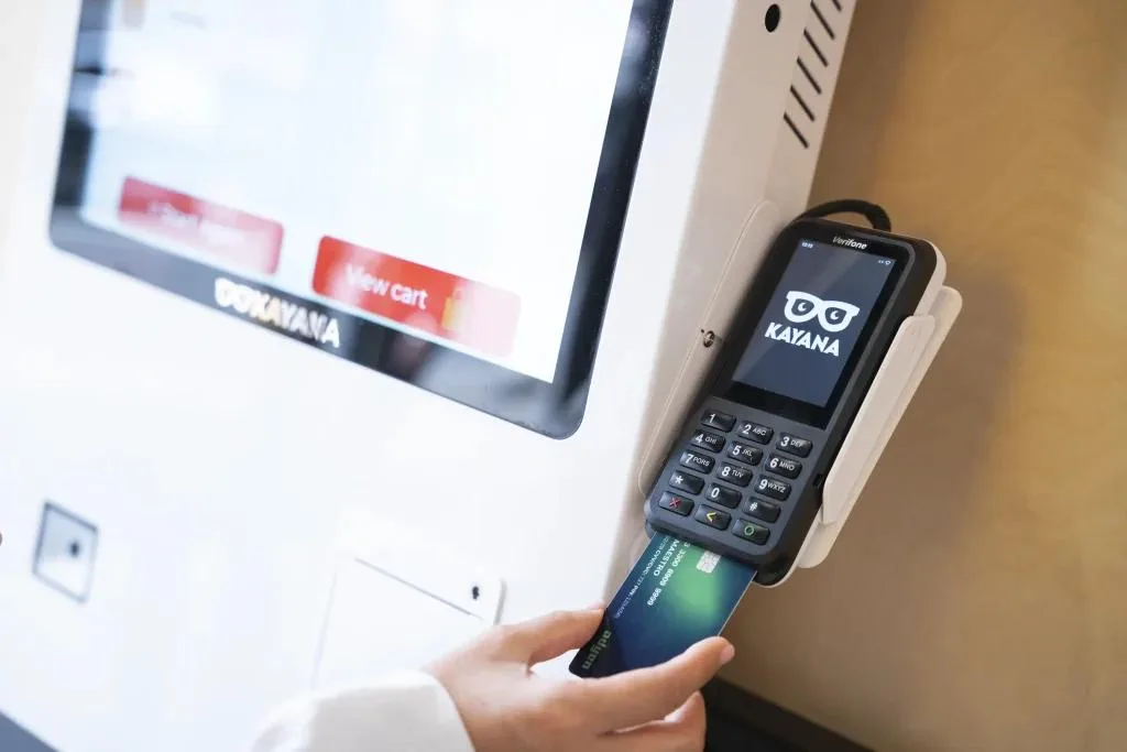 Customer confidently using Kayana's self-service ordering kiosk in modern UK hospitality setting