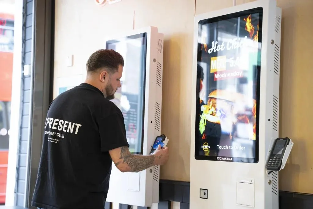 A UK citizen in process of initiating-transaction on a self-service kiosk